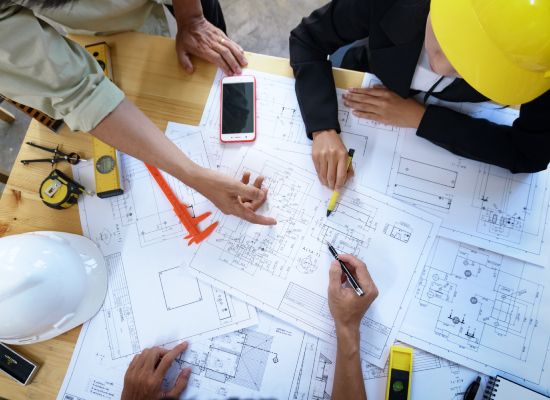 engineer people meeting working and pointing at a drawings in office for discussing. Engineering tools and construction concept.
