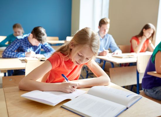 education, learning and people concept - student girl with book writing school test