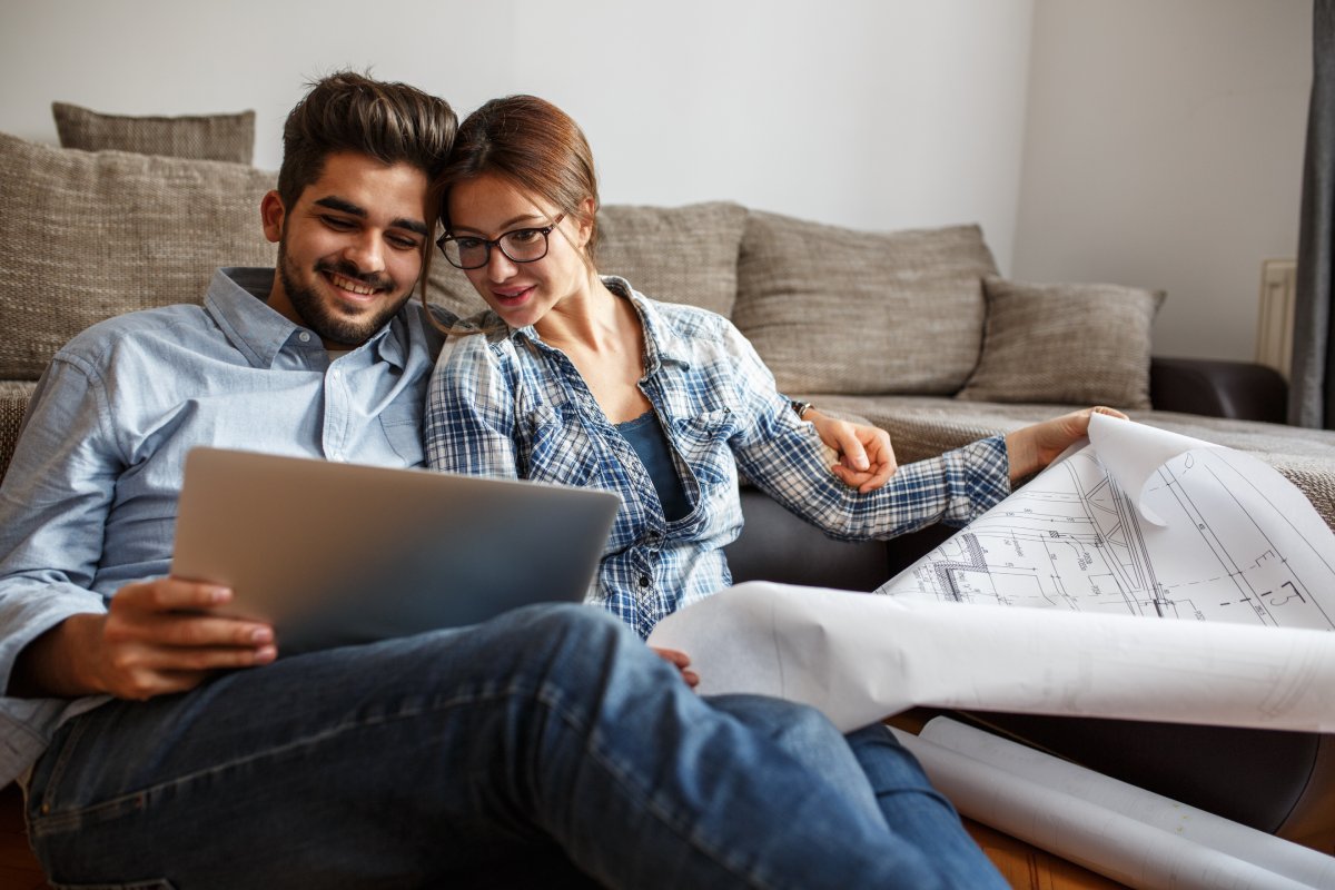Young couple examining blueprints of they new house.Moving house concept.
