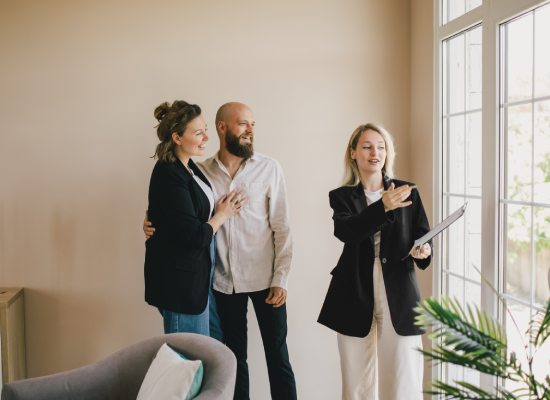 Real estate agent demonstrating a new apartment to a happy couple. Buying a property.
