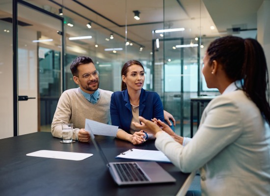 Young couple talking to their financial advisor during a meeting in the office.