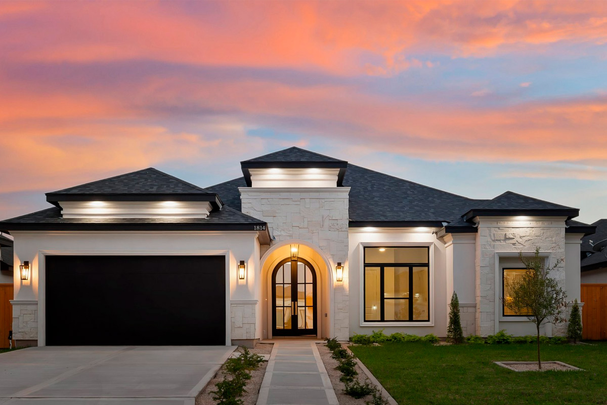 Una impresionante casa silueteada contra una vibrante puesta de sol, que destaca la belleza del paisaje y el estilo de vida de McAllen.