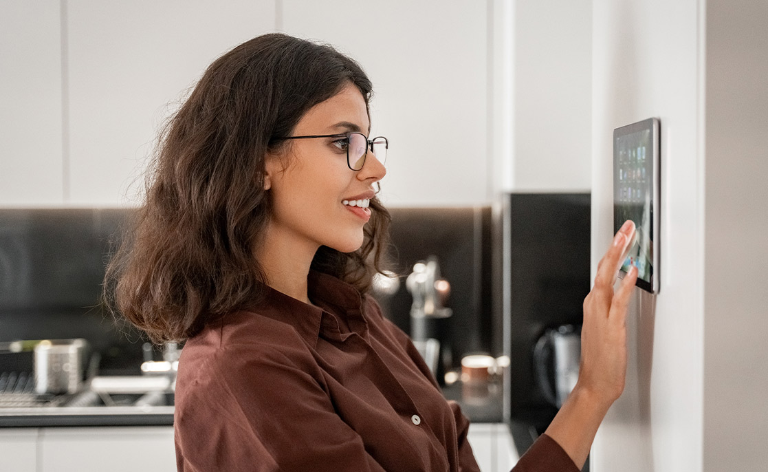 Una mujer con gafas toca una pantalla digital, destacando las características deseadas en viviendas nuevas para compradores en McAllen y Harlingen.