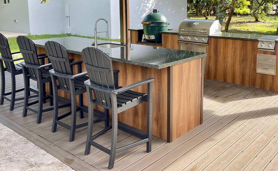 Cocina exterior con estilo, con taburetes de barra y una parrilla, que muestra servicios populares para compradores de viviendas nuevas en McAllen y Harlingen.