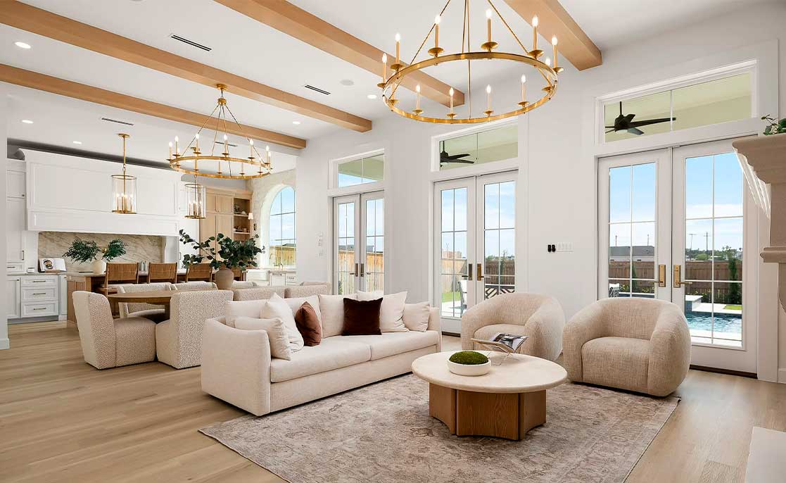 Villa Homes design: A spacious living room adorned with white furniture and a stunning chandelier, highlighting contemporary decor.