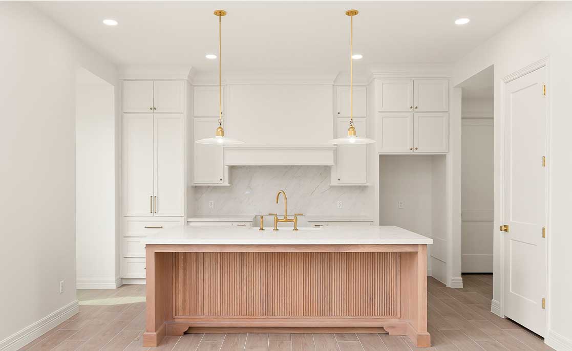 Modern kitchen with sleek white cabinets and rich wooden floors, highlighting desirable features for McAllen, Texas homebuyers.