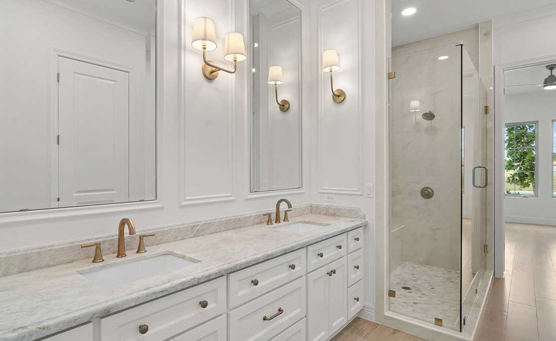 A stylish bathroom featuring marble countertops and white cabinets, highlighting modern design in McAllen, Texas neighborhoods.