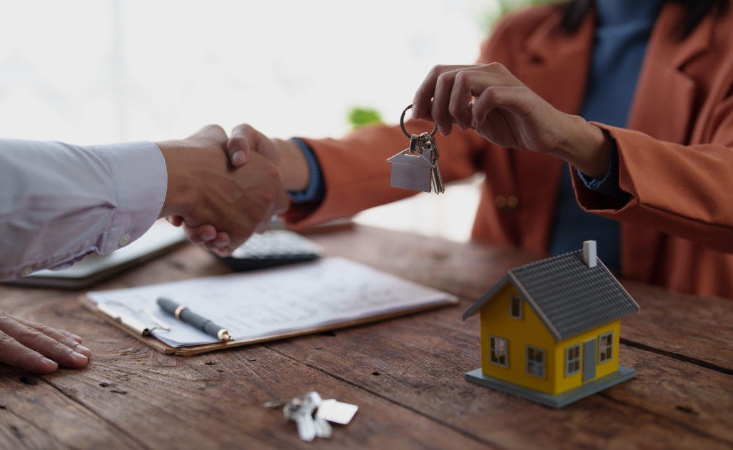 Business people sealing a real estate agreement with a handshake, symbolizing a successful partnership and the transfer of property ownership in a housing transaction
