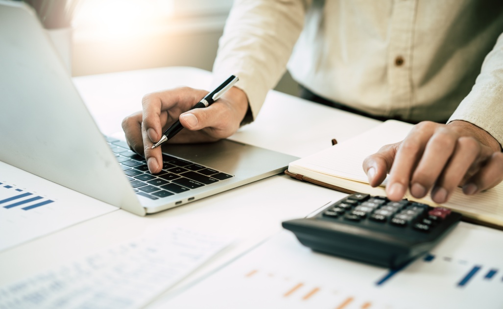 Deduction planning, debt asian accountant hand using calculator to calculating money balance from bill and income, cost budget expenses for pay money form personal individual on table at home.